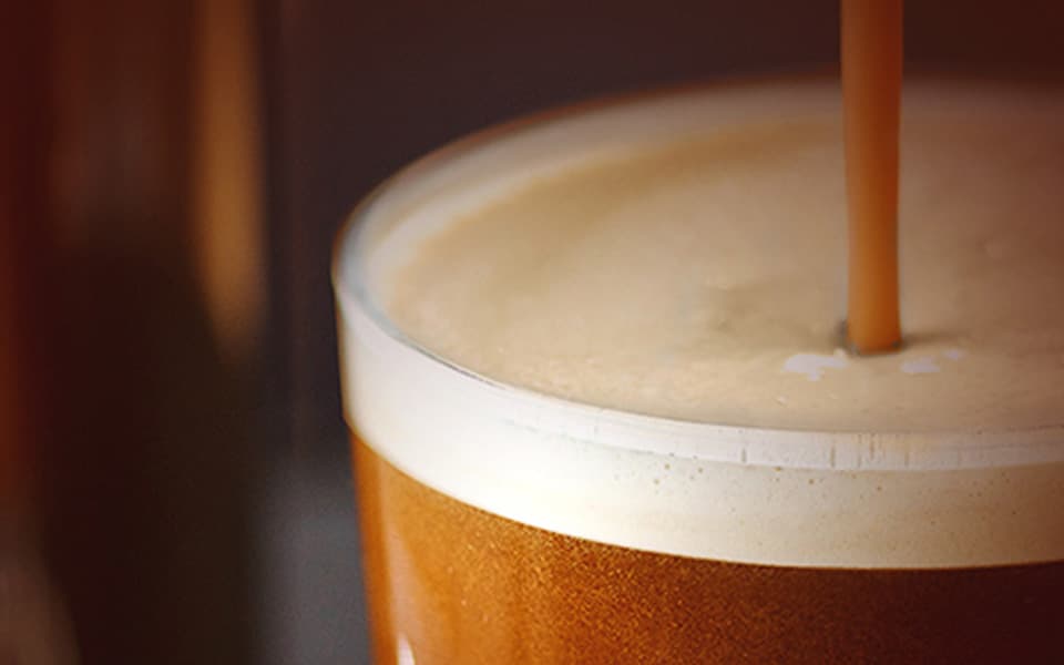 Cold brew coffee from a PET keg tap being poured into a glass cup
