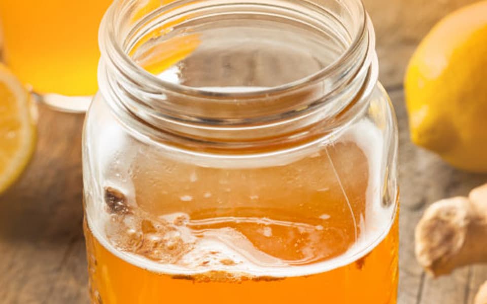 Jar on a wooden table filled with kombucha